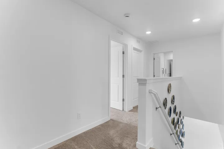 White painted walls, recessed lighting, white interior doors, and carpeted flooring