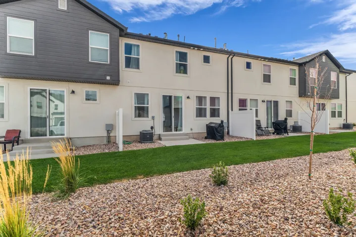 Rear exterior with light stucco finish and dark siding accents