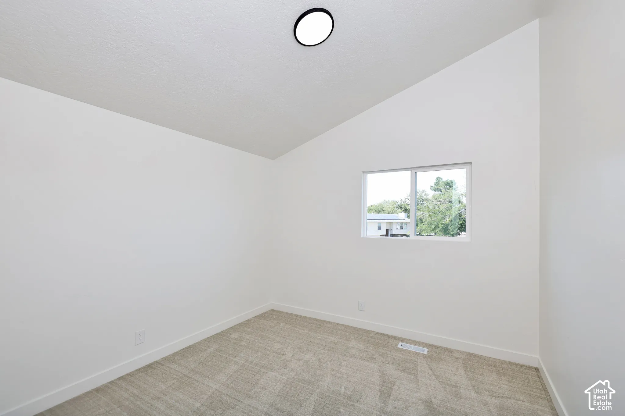 Vaulted ceiling, recessed lighting, double-pane window, and neutral carpeting