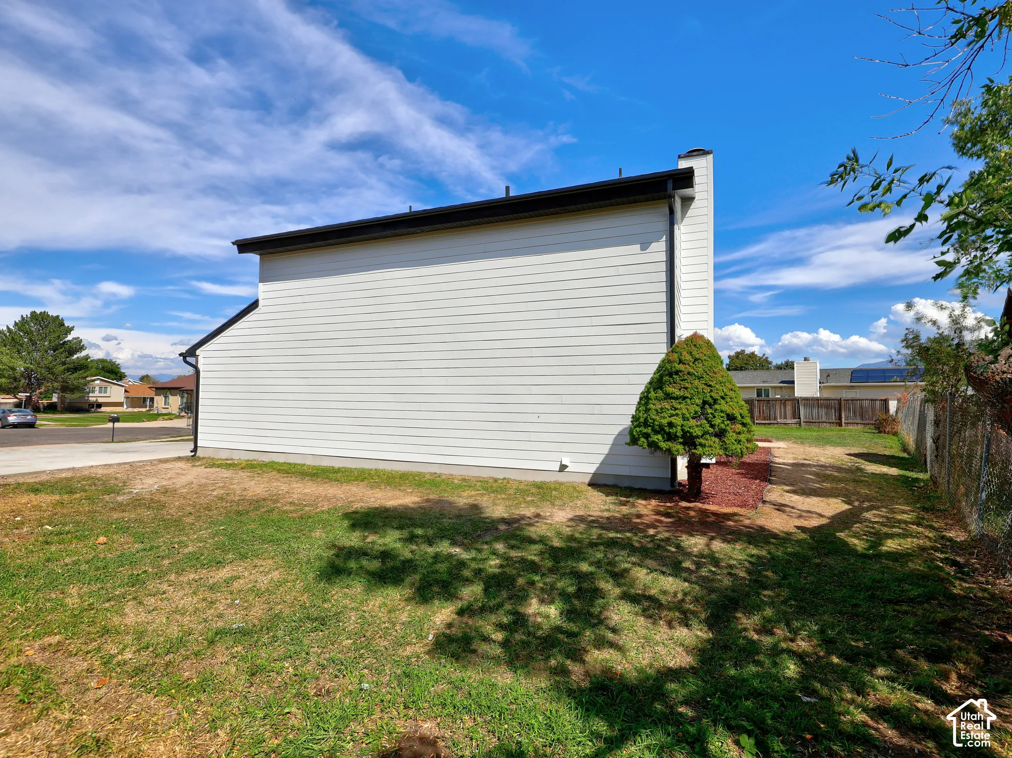 White horizontal siding exterior with black roofline and downspout