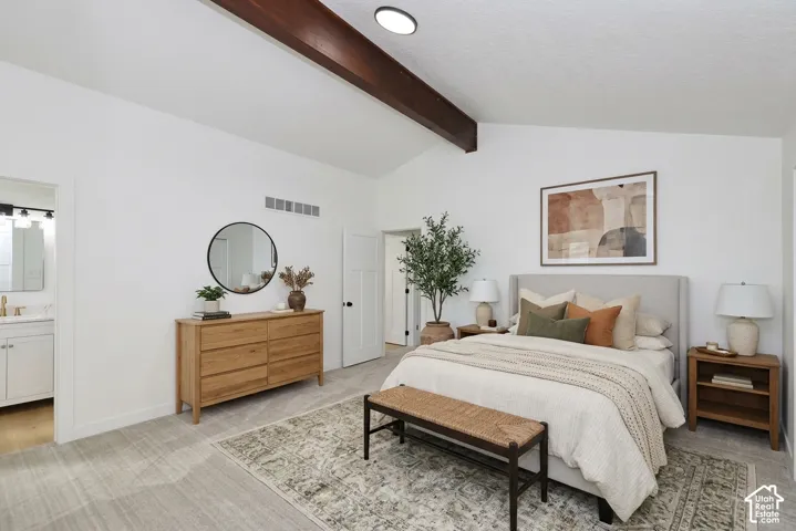 Vaulted ceiling with exposed wood beams, neutral wall finishes, and a framed art piece