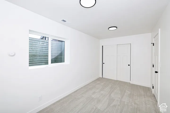 Recessed lighting, light-toned carpeting, white walls, white trim, and a white sliding closet door