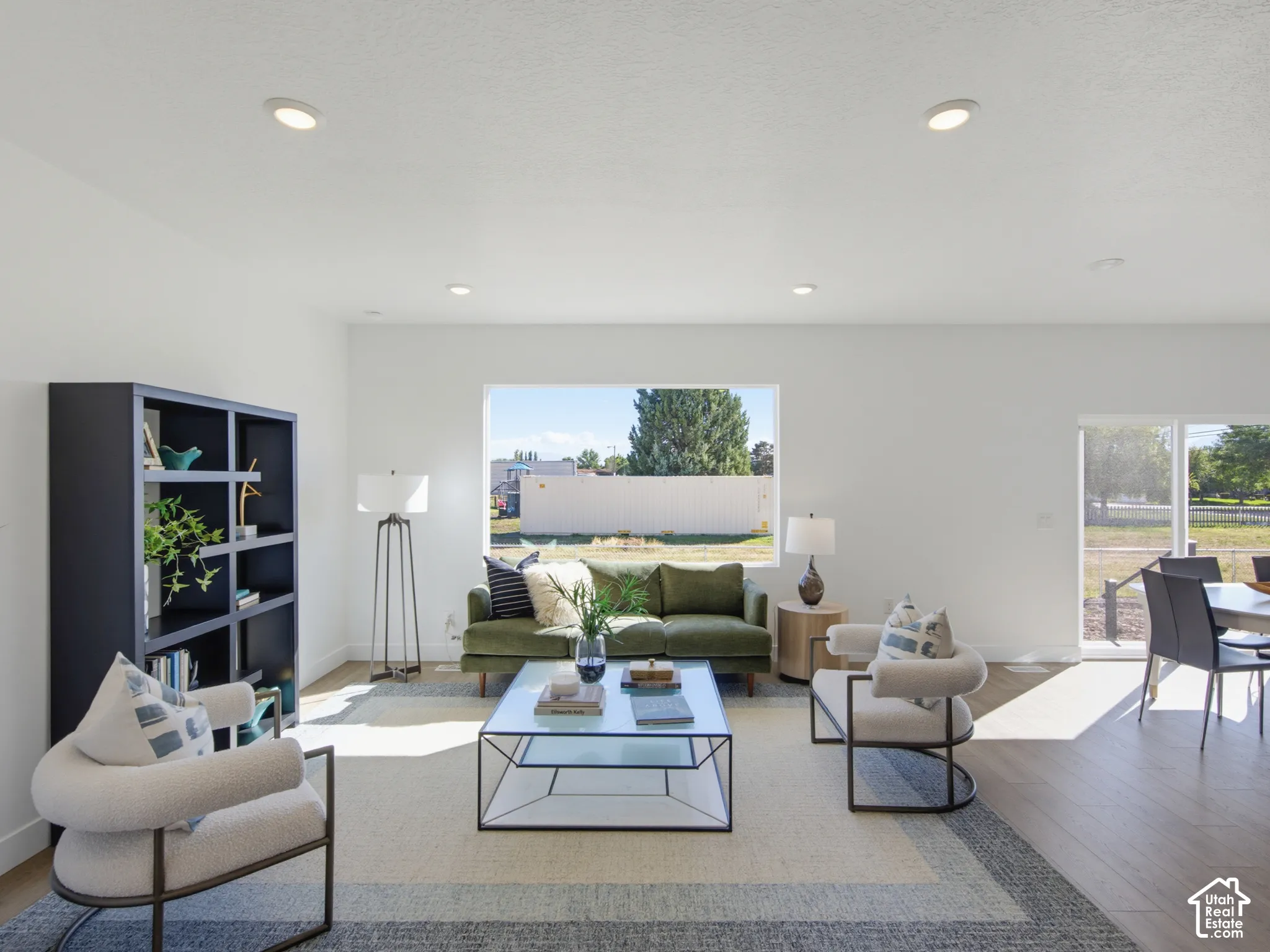 Open-concept living space featuring wood-finish flooring, recessed lighting, and large picture windows
