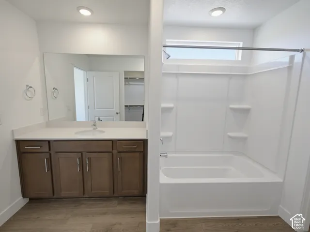 Built-in vanity with a single basin sink, white countertop, and wood-finish cabinetry