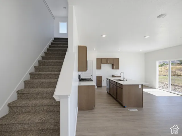 Open-concept living space with wood-finish flooring, recessed lighting, and a sliding glass door