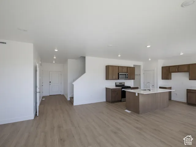 Open-concept living space with wood-finish flooring, recessed lighting, and a modern kitchen