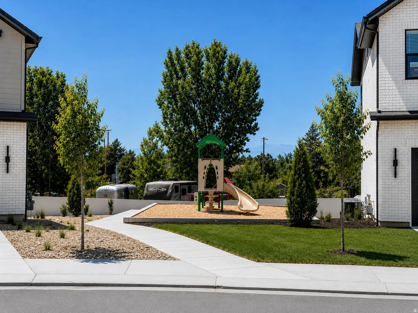 Community playground featuring a slide and climbing structure on a wood chip base