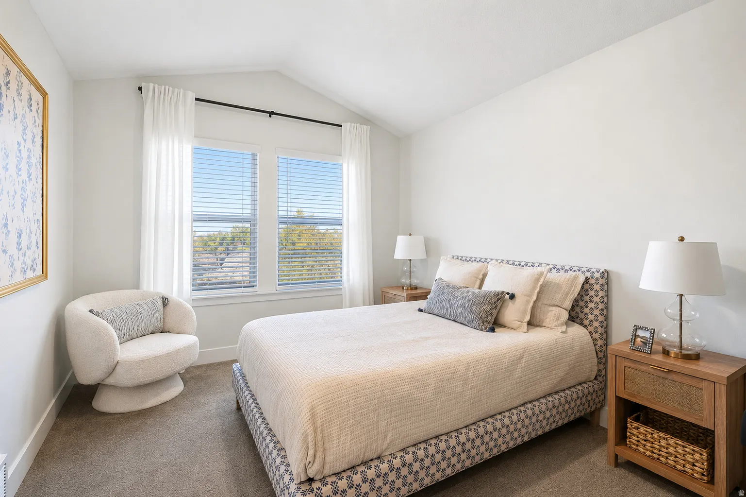 Vaulted ceiling with an accent wall, two large windows with blinds, and carpeted flooring
