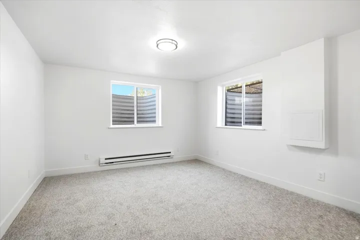 Plush carpeted flooring, two windows, and flush-mount ceiling light fixture