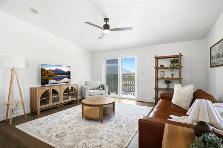 Recessed lighting, wood-finish flooring, ceiling fan with integrated light, sliding glass door, and a built-in shelving unit