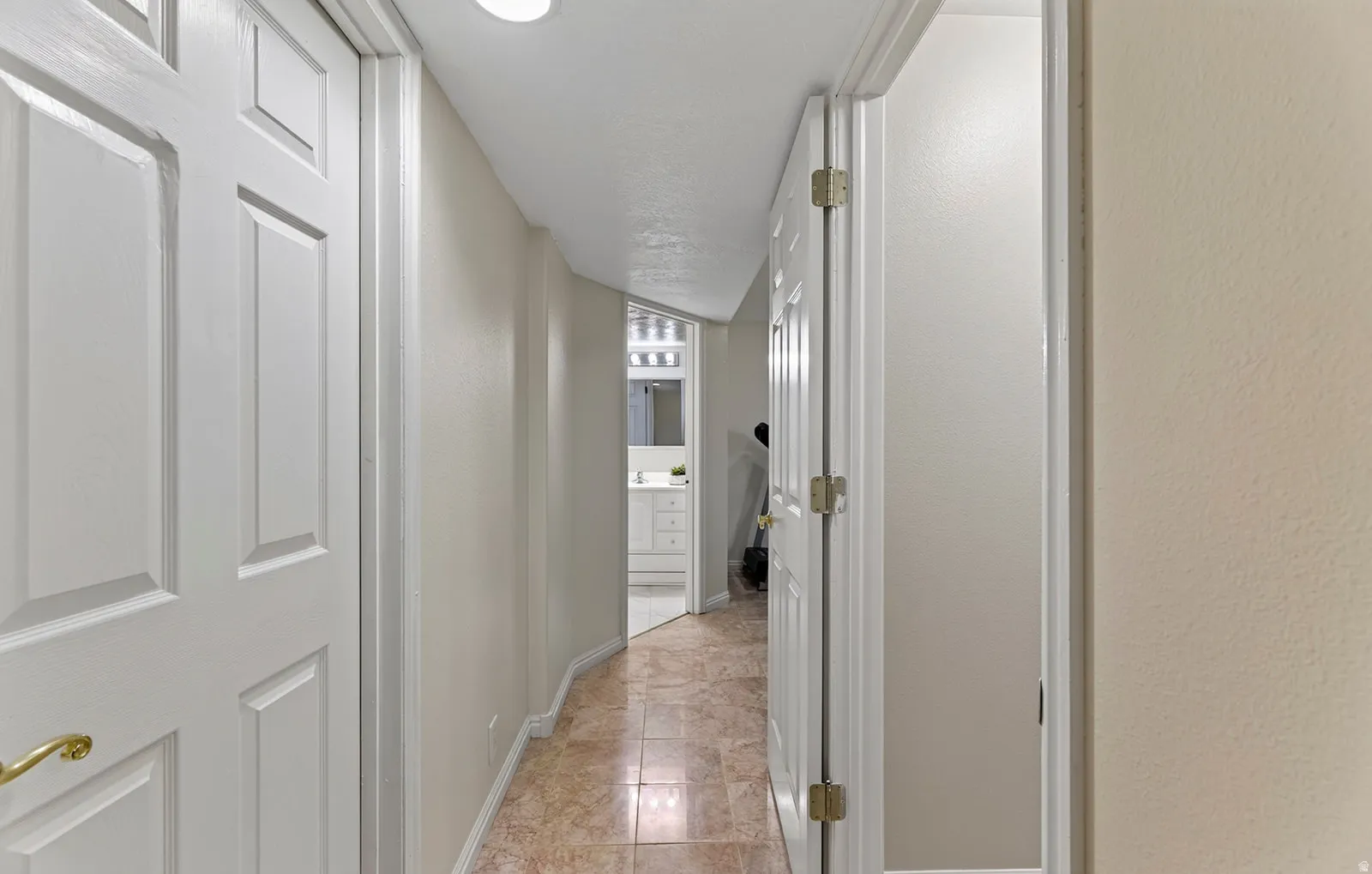 Hallway with tile flooring, recessed lighting, and panel doors