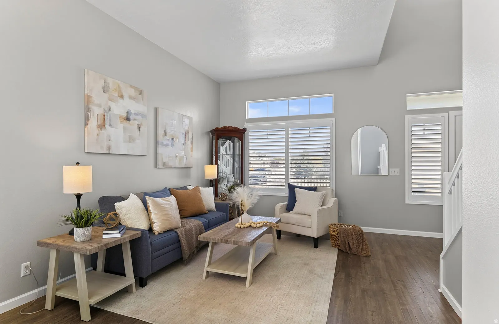 Vaulted ceiling, wood-finish flooring, white plantation shutters, transom windows, and neutral wall tones