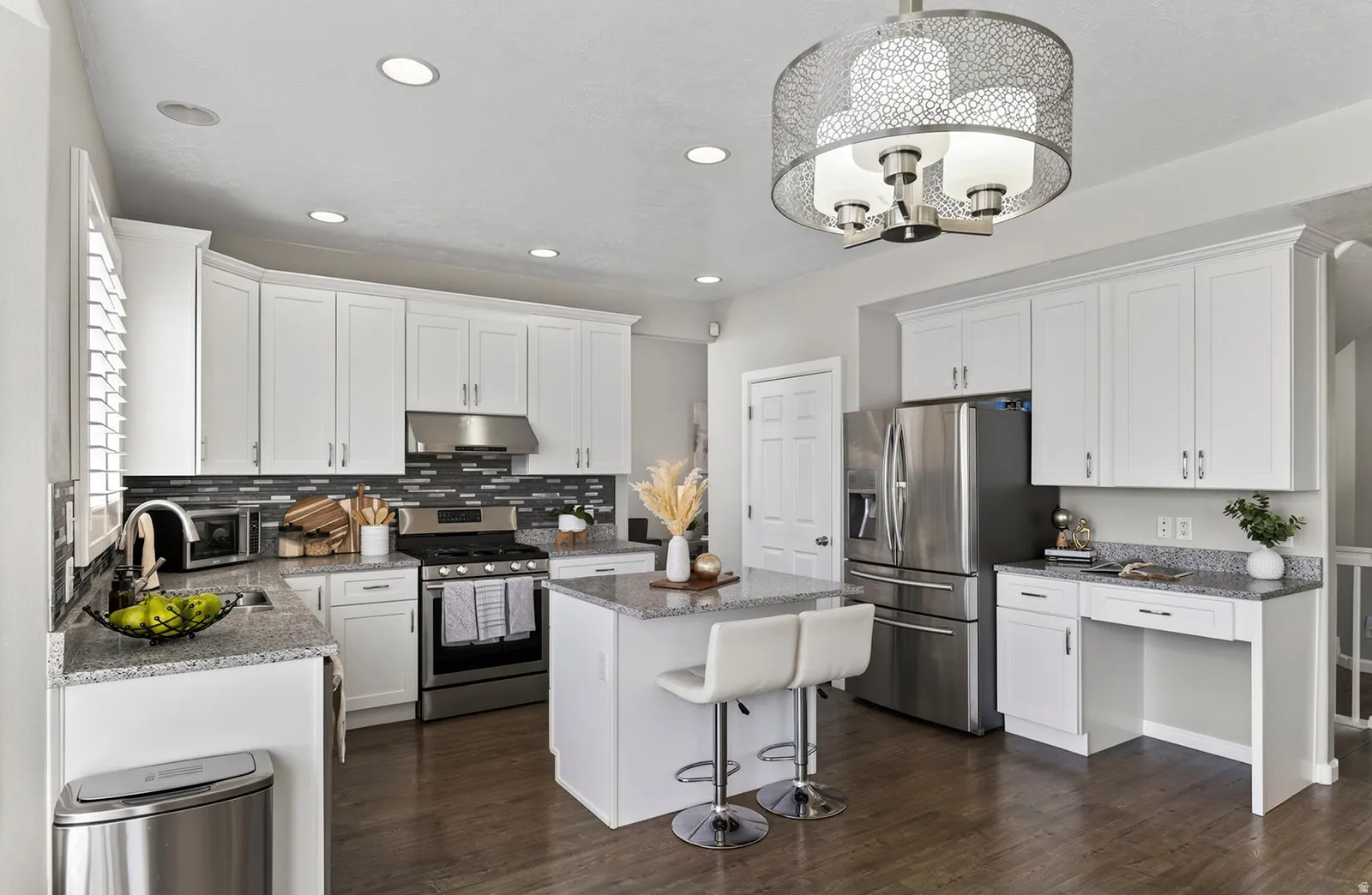 White cabinetry, recessed lighting, granite countertops, stainless steel appliances, and wood-finish flooring