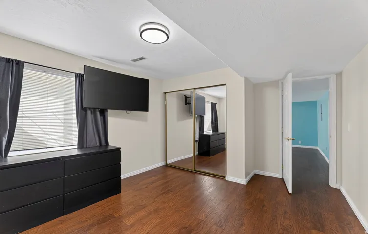 Wood-finish flooring, mirrored closet doors, and recessed lighting