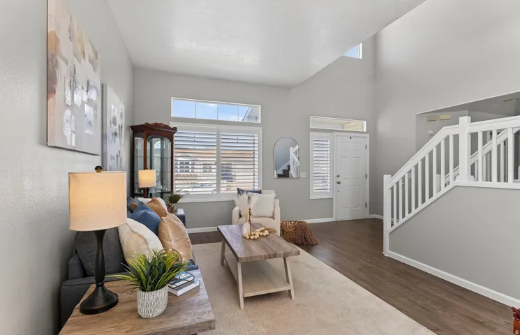 Vaulted ceilings, wood-finish flooring, white staircase, and transom windows