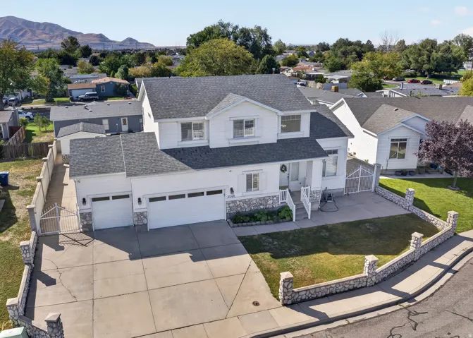 Two-story residence with a multi-car garage, stone facade accents, and a paved driveway