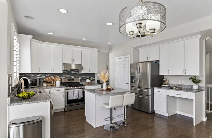 White cabinetry, recessed lighting, granite countertops, stainless steel appliances, and wood-finish flooring