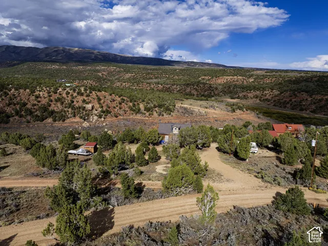Expansive rural landscape featuring multiple structures, natural terrain, and distant mountain ranges