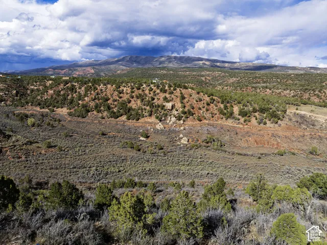 Expansive terrain featuring natural vegetation, distant mountain range, and a layered landscape