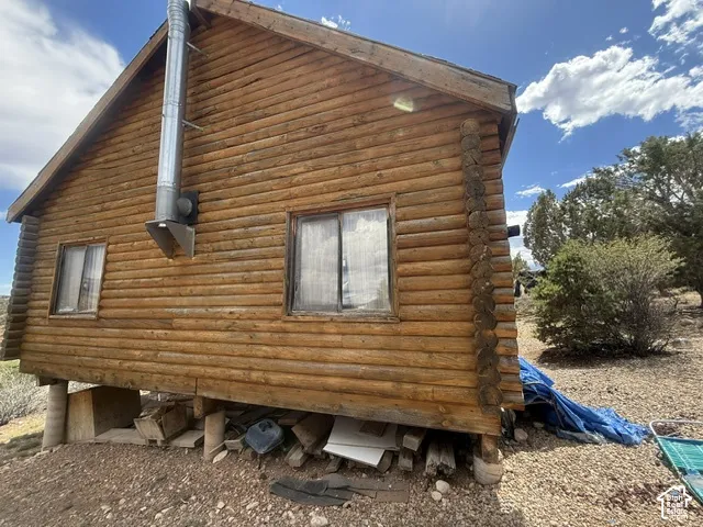 Log-sided cabin with a gable roof and visible window frames