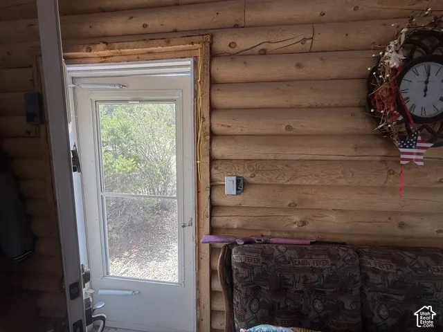 Log-style interior wall with a white storm door