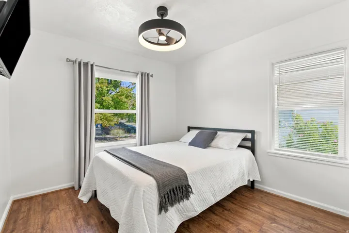 Wood-finish flooring, white walls, and a contemporary ceiling fan with integrated lighting
