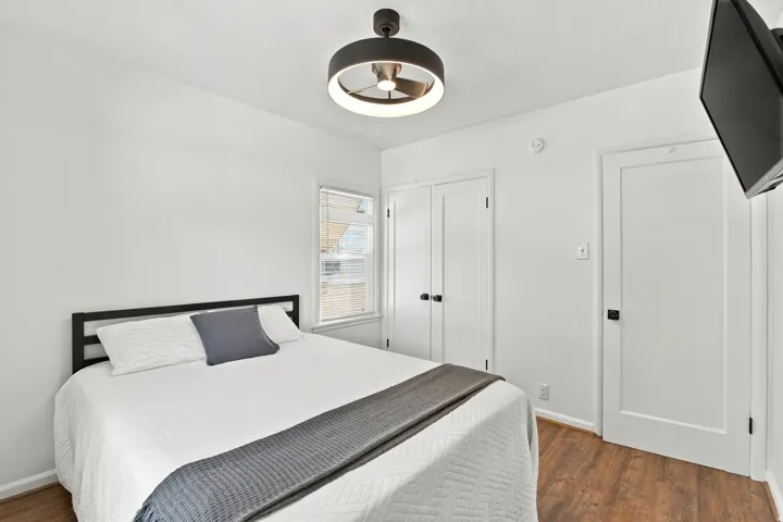 Wood-finish flooring, white walls, and a modern ceiling fan with integrated lighting