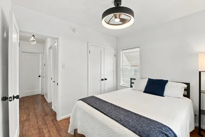 White walls, wood-finish flooring, and a contemporary ceiling light fixture