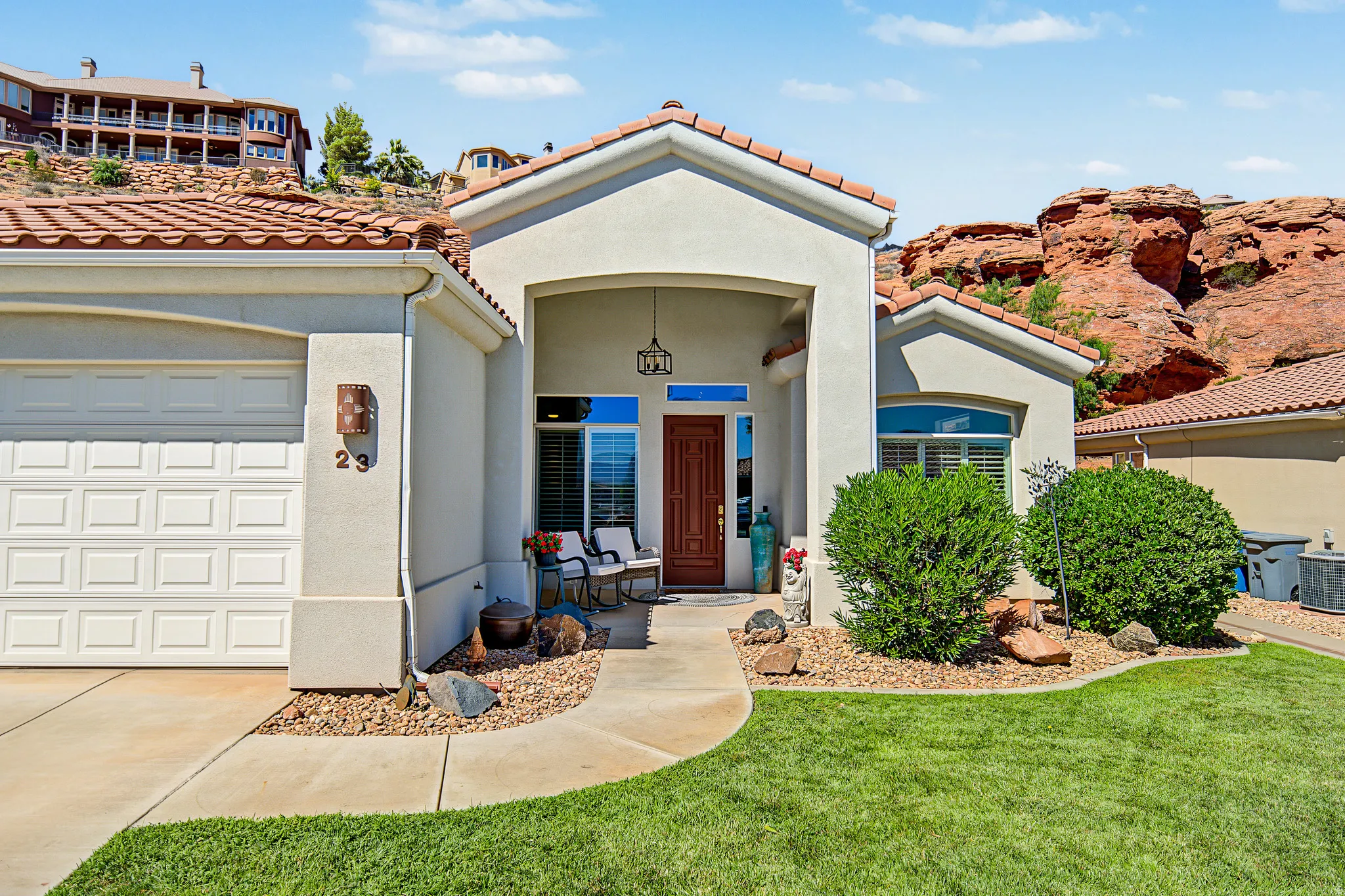 Stucco exterior with a tile roof, covered entry, and an integrated two-car garage