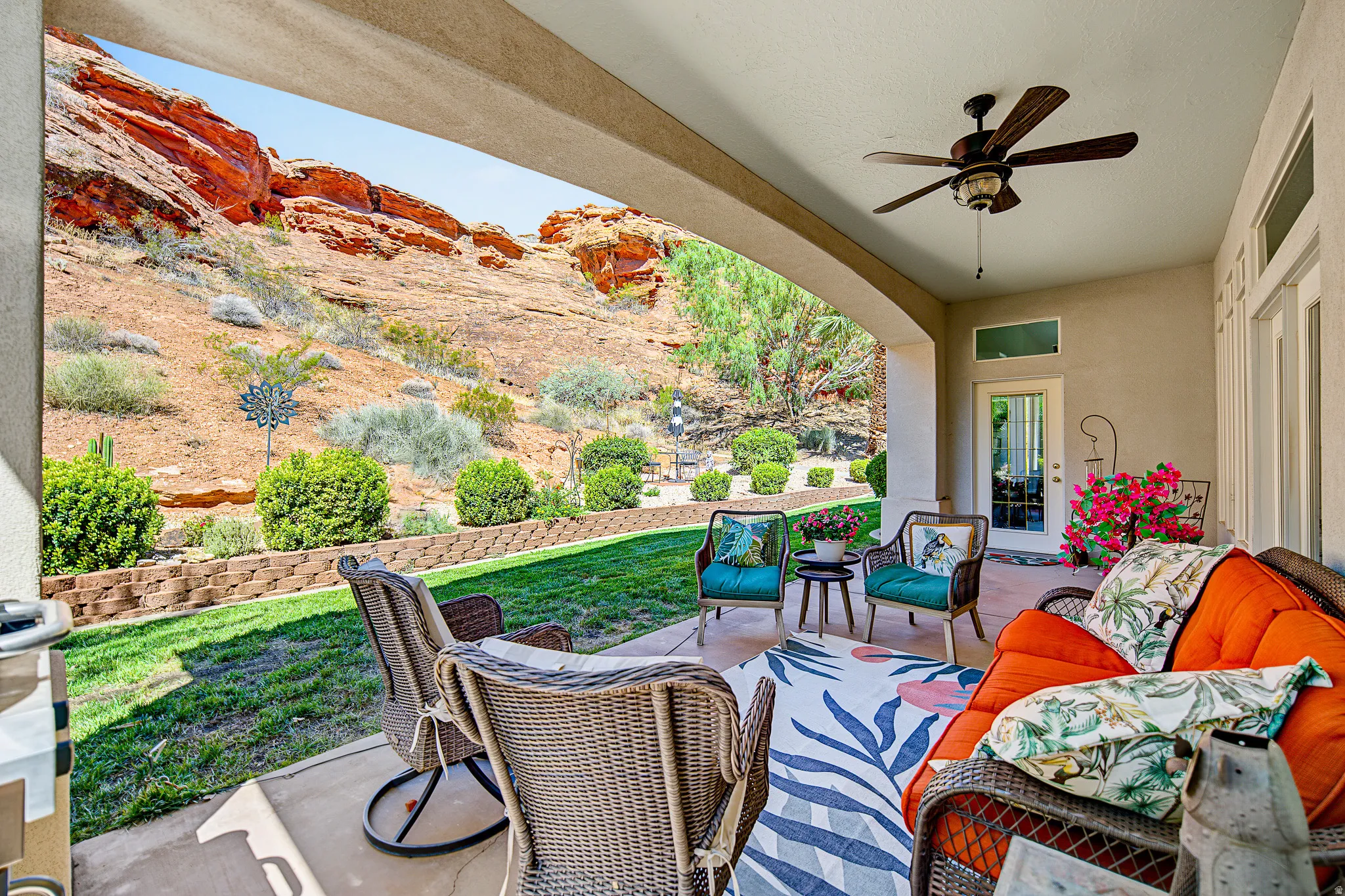 Covered patio with an arched entry and ceiling fan, featuring an integrated concrete surface