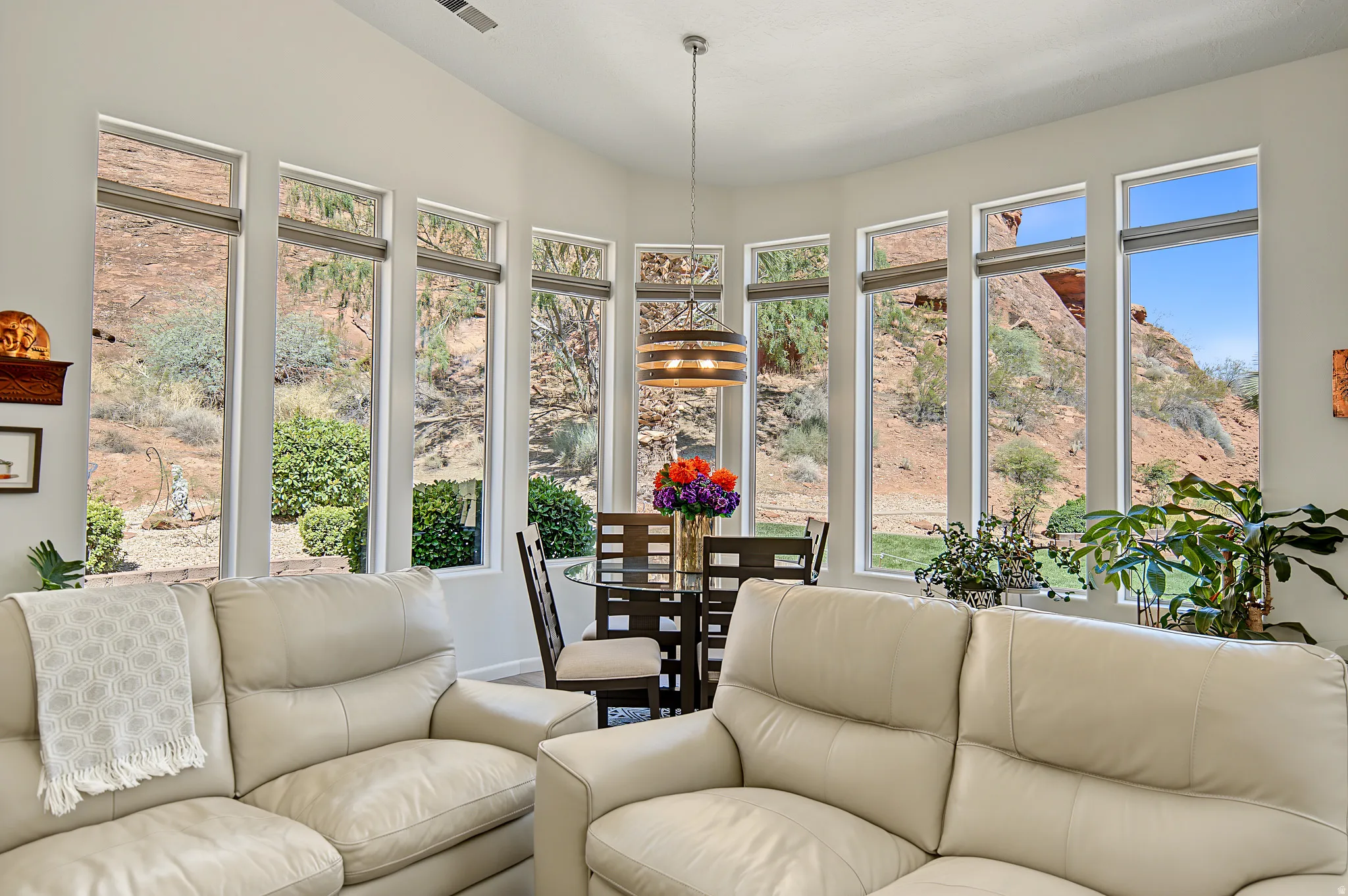 Bay window dining area with a contemporary chandelier, surrounded by multiple large windows, offering abundant natural light
