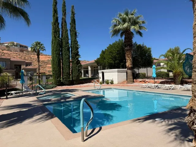 Outdoor swimming pool with integrated spa and surrounding concrete decking