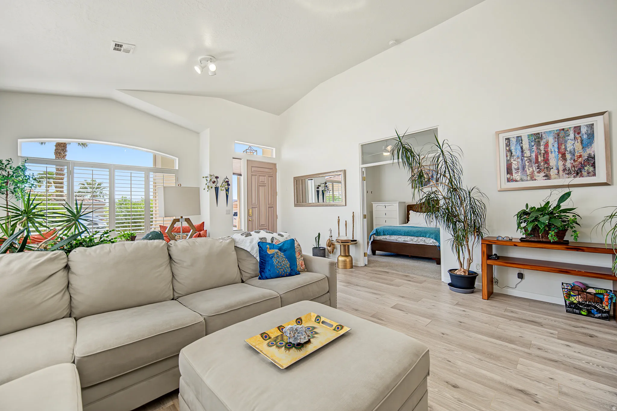 Vaulted ceiling, arched transom window, shuttered window, wood-finish flooring, and recessed lighting