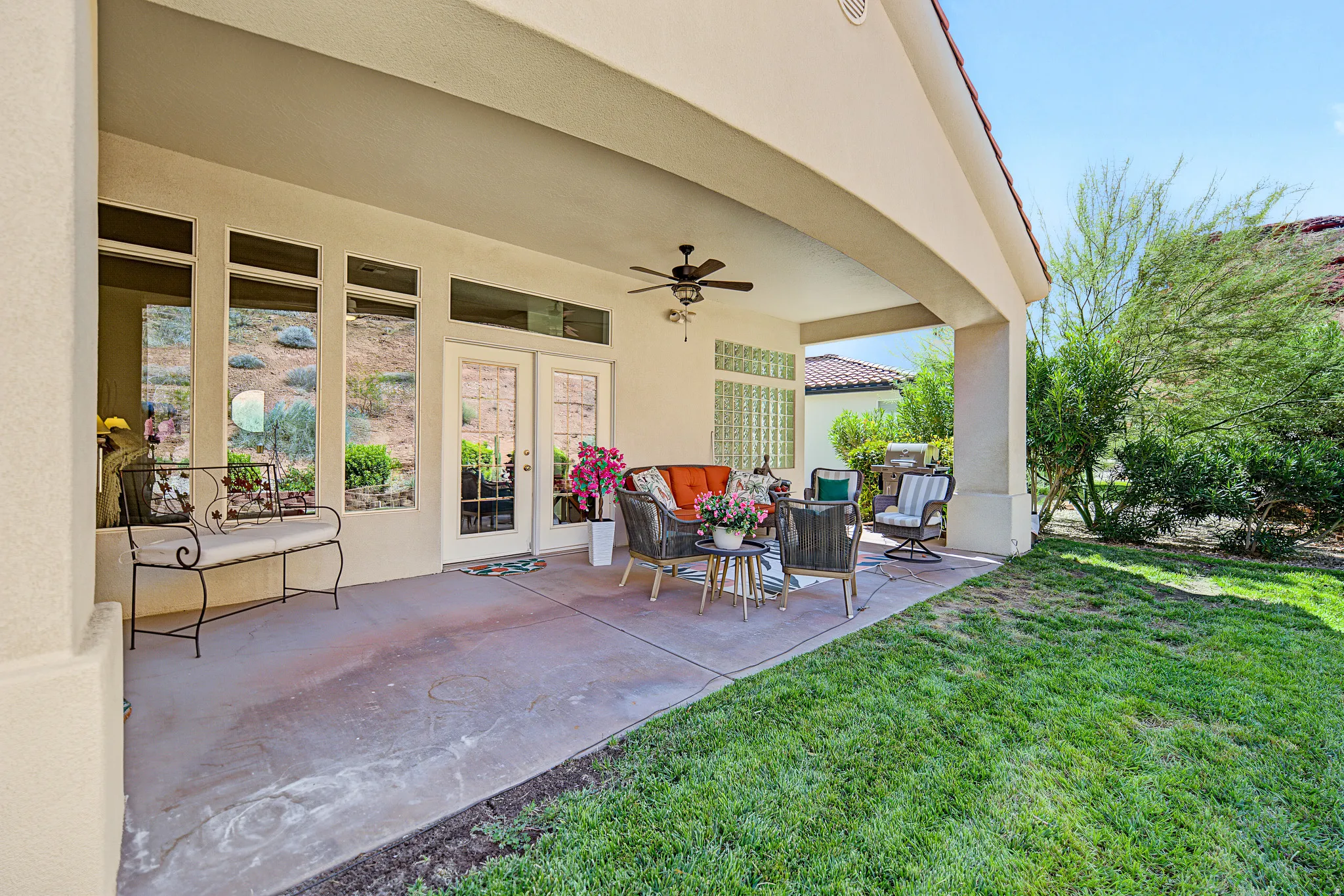Covered patio with a ceiling fan, concrete flooring, and direct access through glass French doors