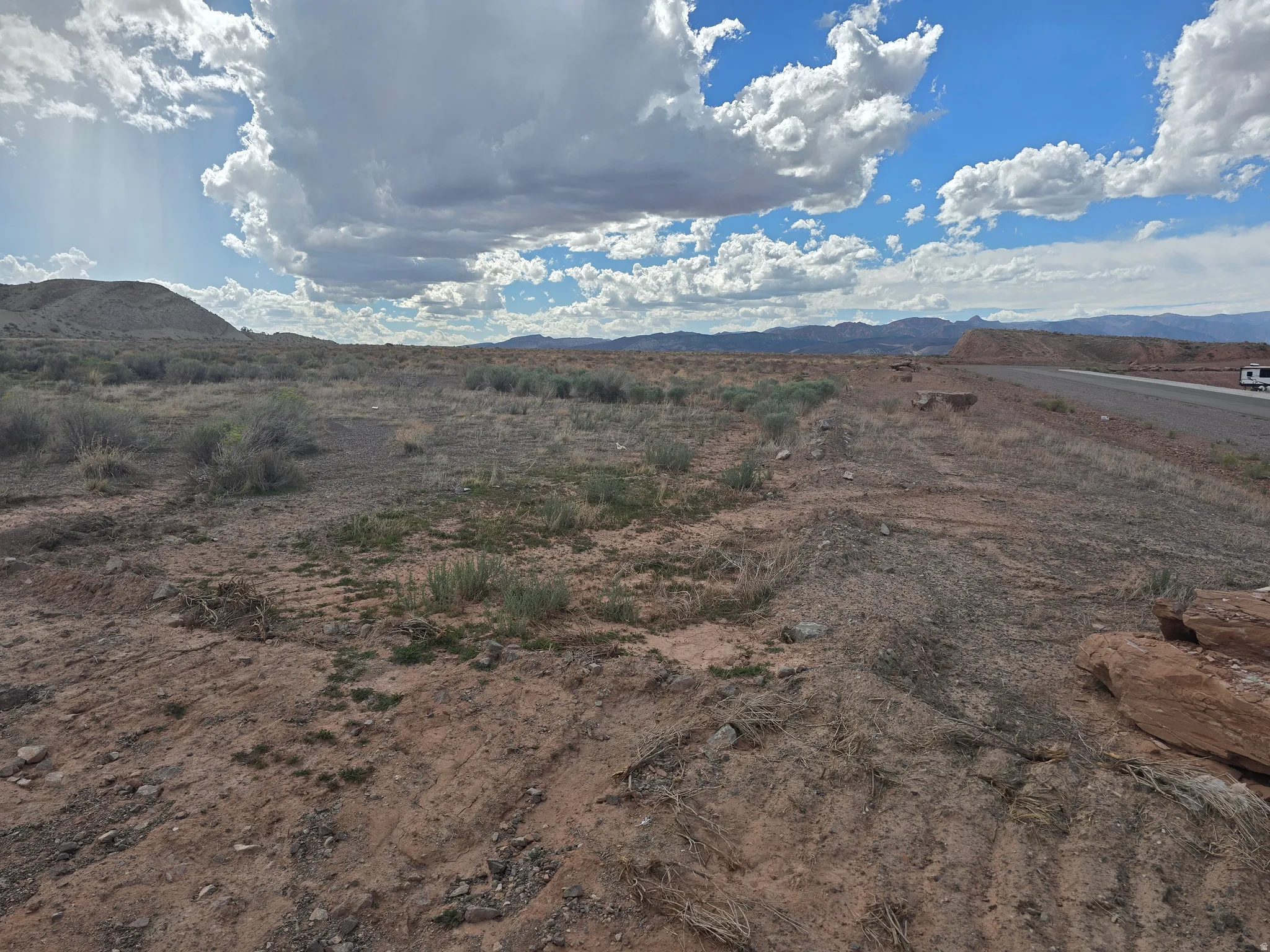 Expansive undeveloped land featuring natural terrain and distant mountains