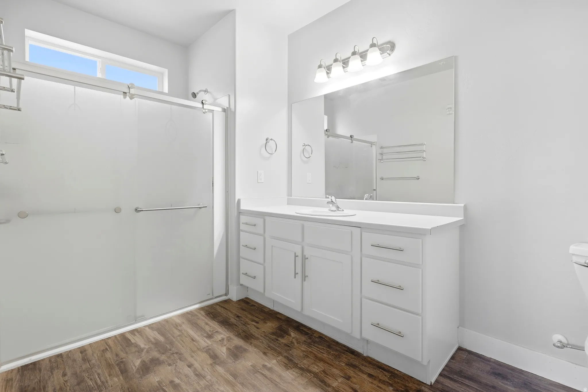 White vanity with integrated sink, coordinating countertop, and ample storage