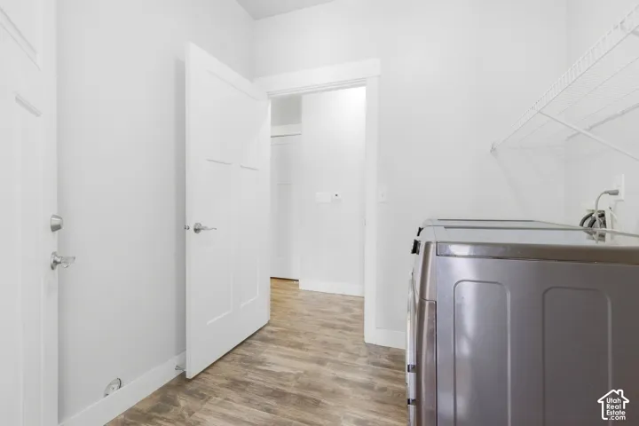 Laundry area with wood-finish flooring, white walls, and built-in wire shelving