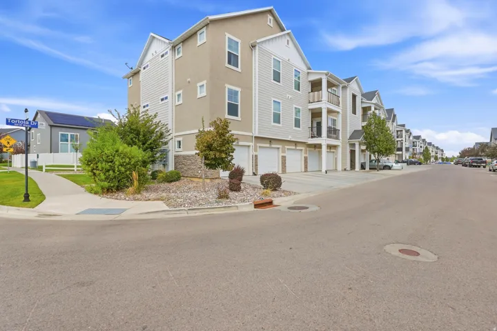 Three-story multi-unit structure featuring light-colored siding and stucco exterior