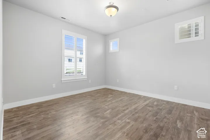 Wood-finish flooring, white trim, and two windows