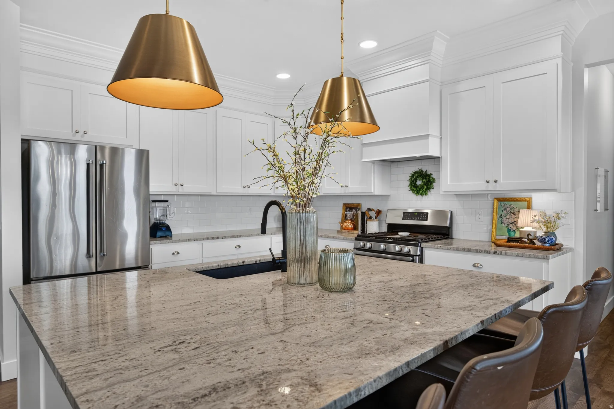 Kitchen featuring white cabinetry, stainless steel appliances, a white subway tile backsplash, and a large island with a stone countertop