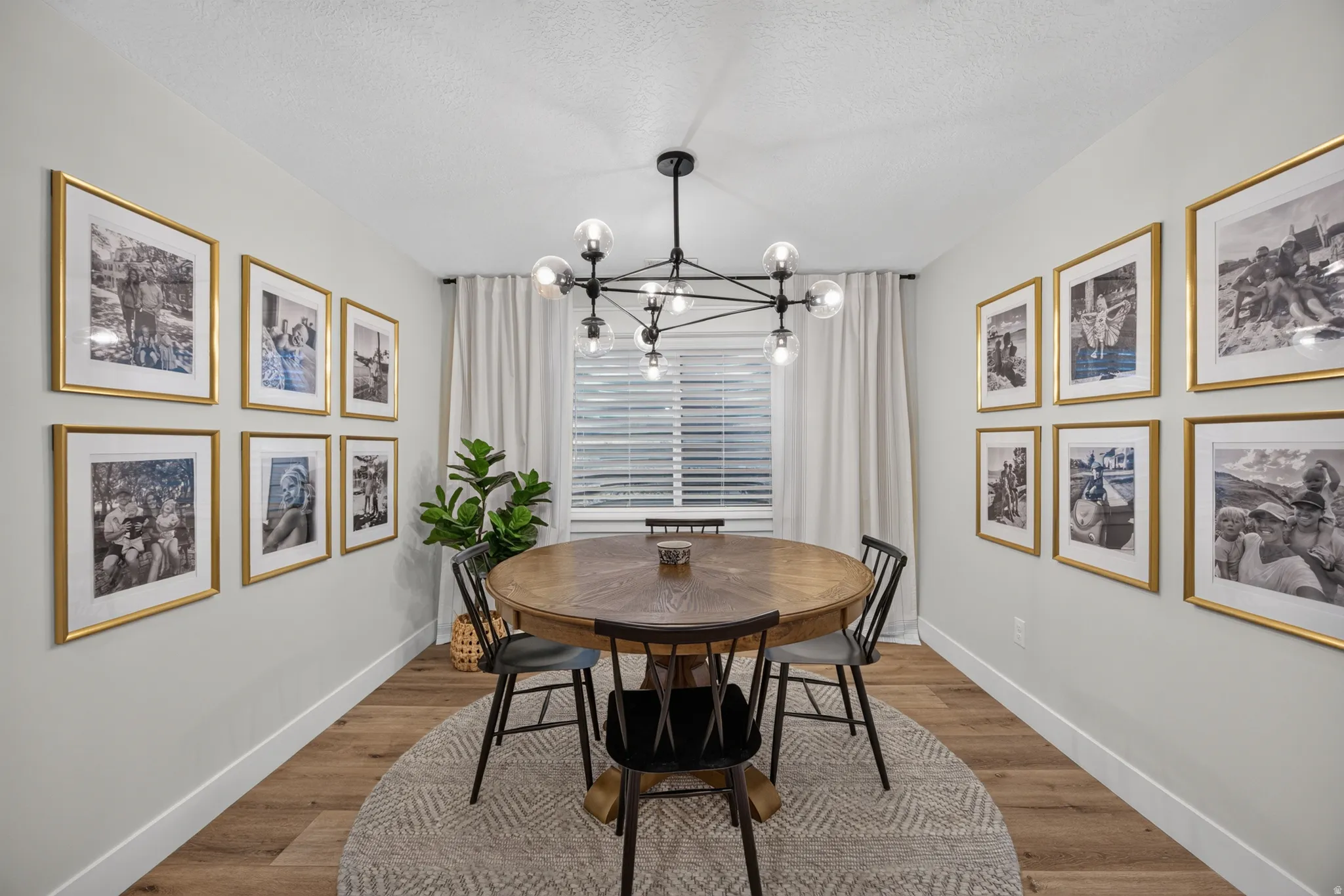 Recessed lighting, wood-finish flooring, and a modern chandelier