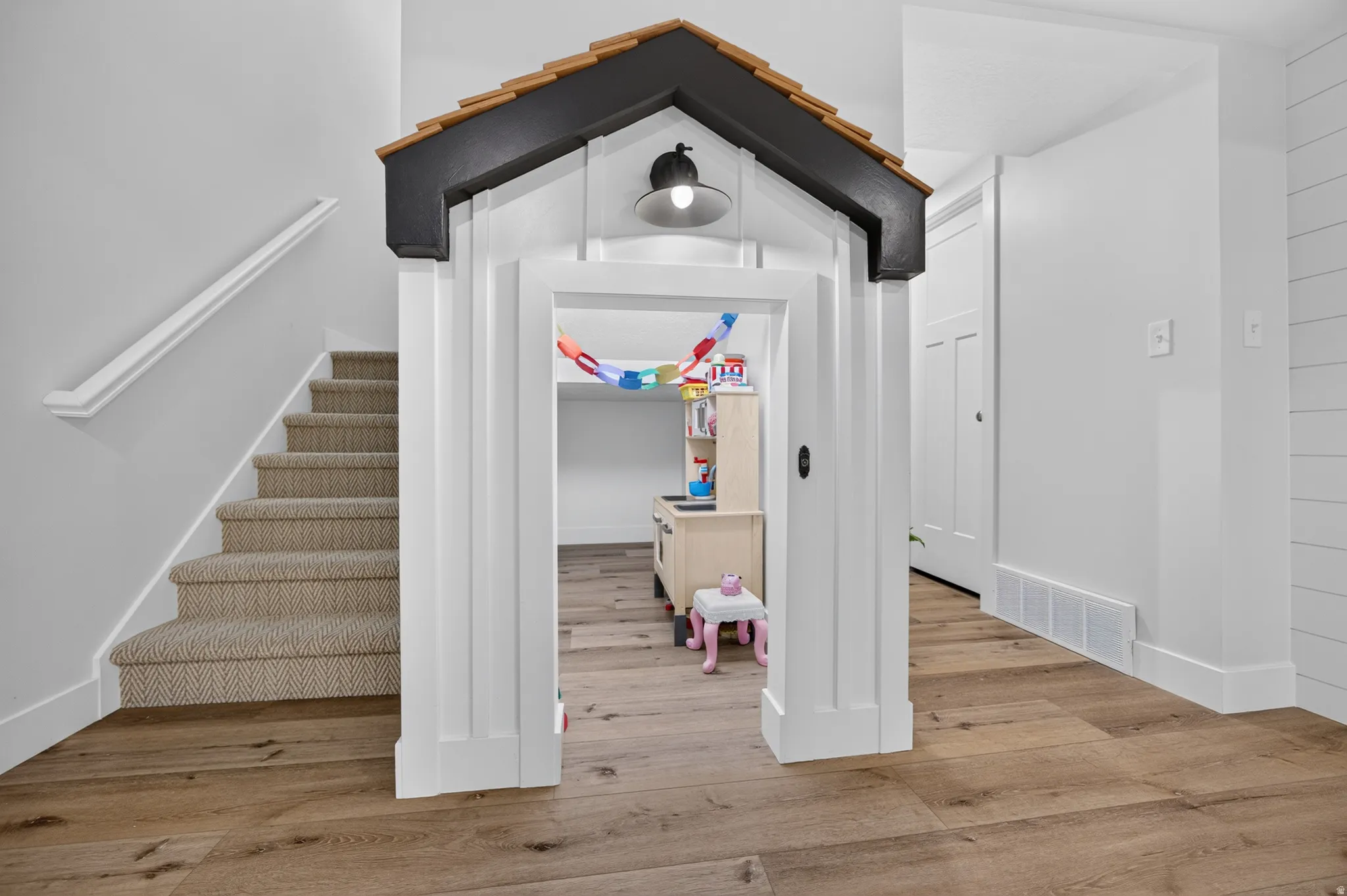 Wood-finish flooring with a decorative playhouse entrance