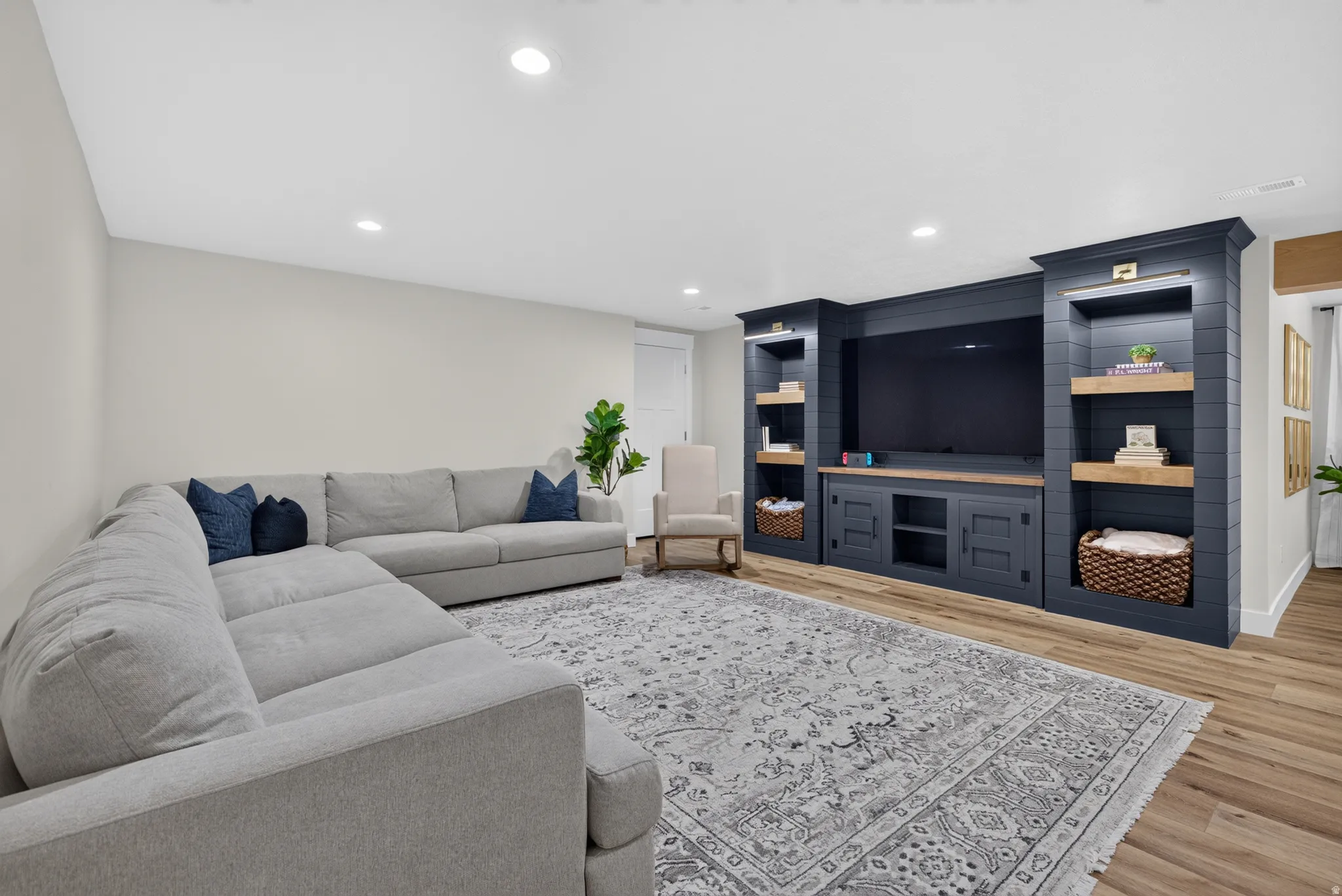 Built-in media center with wood-finish shelving, recessed lighting, and integrated cabinetry