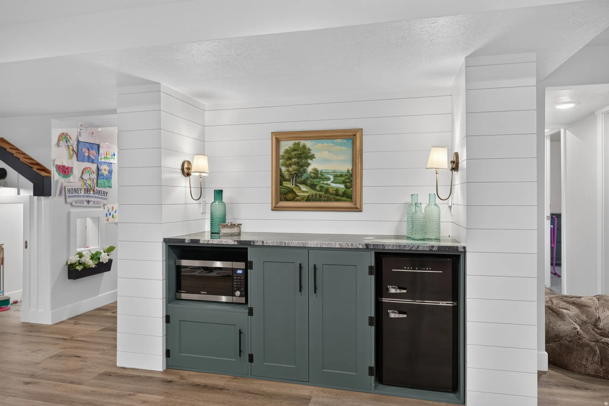 Built-in cabinetry with a stone-finish countertop, integrated microwave, and compact refrigerator