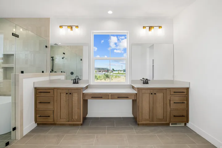 Dual wood-finish vanities with light-toned countertops and integrated sinks