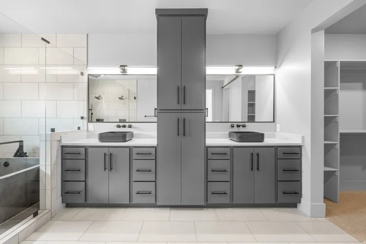 Double vanity with gray cabinetry, white countertops, and vessel sinks