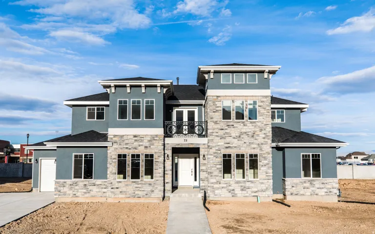 Contemporary exterior with stone veneer and stucco finishes, multiple window configurations, a prominent entry, and an attached garage