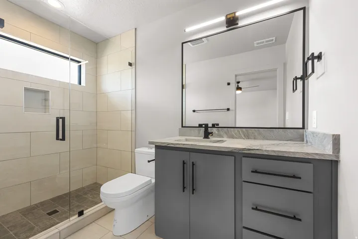 Glass-enclosed shower with a built-in niche and transom window