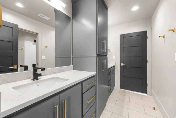 Dual vanity with white countertop, integrated rectangular sinks, and matte black fixtures