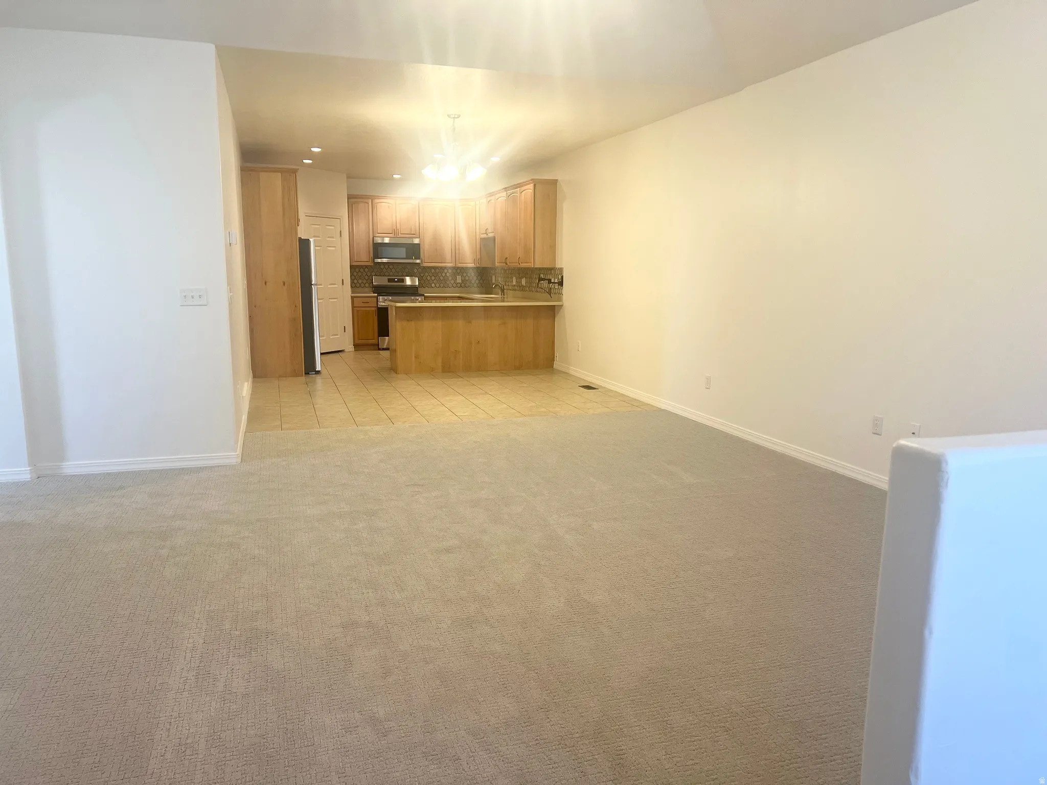 Kitchen with wood-finish cabinetry, tile flooring, and stainless steel appliances